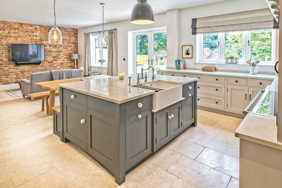 Large contemporary u-shaped open plan kitchen in West Midlands with a double-bowl sink, shaker cabinets, grey cabinets, marble worktops, yellow splashback, marble splashback, black appliances, limestone flooring, an island, beige floors and grey worktops.