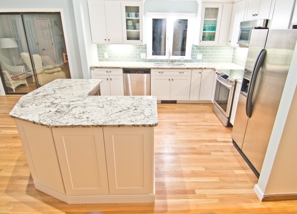 Eat-in kitchen - small transitional l-shaped light wood floor and beige floor eat-in kitchen idea in Boston with an undermount sink, shaker cabinets, white cabinets, green backsplash, subway tile backsplash, stainless steel appliances, an island and gray countertops