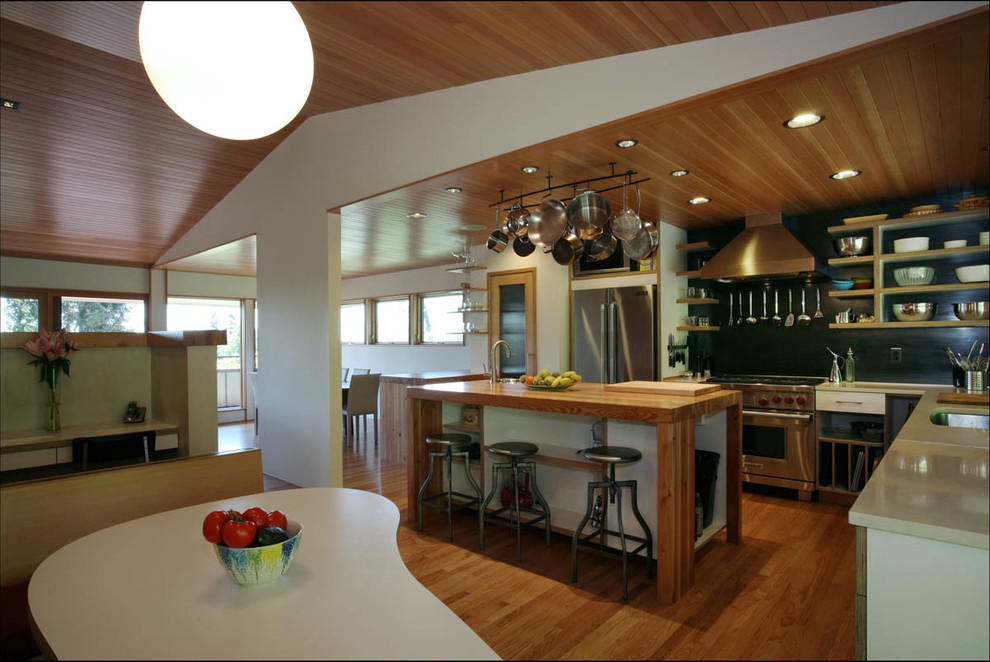 ポートランドにあるミッドセンチュリースタイルのおしゃれなキッチン (アンダーカウンターシンク、黒いキッチンパネル、グレーのキッチンカウンター、淡色無垢フローリング) の写真