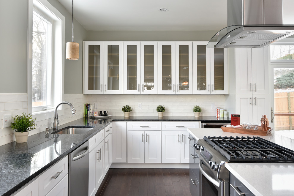 ボストンにあるトラディショナルスタイルのおしゃれなキッチン (アンダーカウンターシンク、ガラス扉のキャビネット、白いキャビネット、クオーツストーンカウンター、白いキッチンパネル、サブウェイタイルのキッチンパネル、シルバーの調理設備、濃色無垢フローリング) の写真