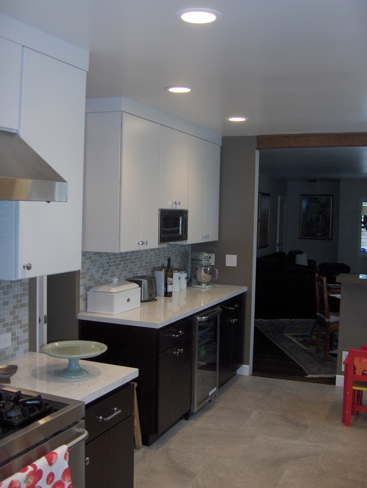 This is an example of a medium sized contemporary single-wall kitchen/diner in San Francisco with a submerged sink, flat-panel cabinets, stainless steel appliances, dark wood cabinets, tile countertops, multi-coloured splashback, stone tiled splashback, ceramic flooring and no island.