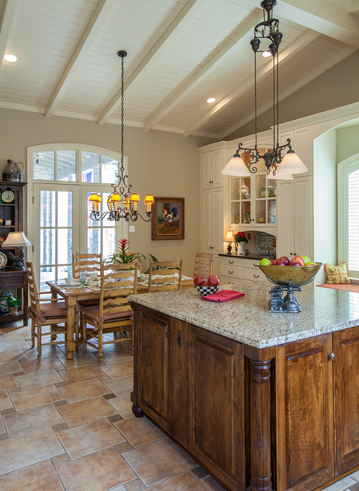 This is an example of a large traditional u-shaped enclosed kitchen in Dallas with raised-panel cabinets, dark wood cabinets and granite worktops.