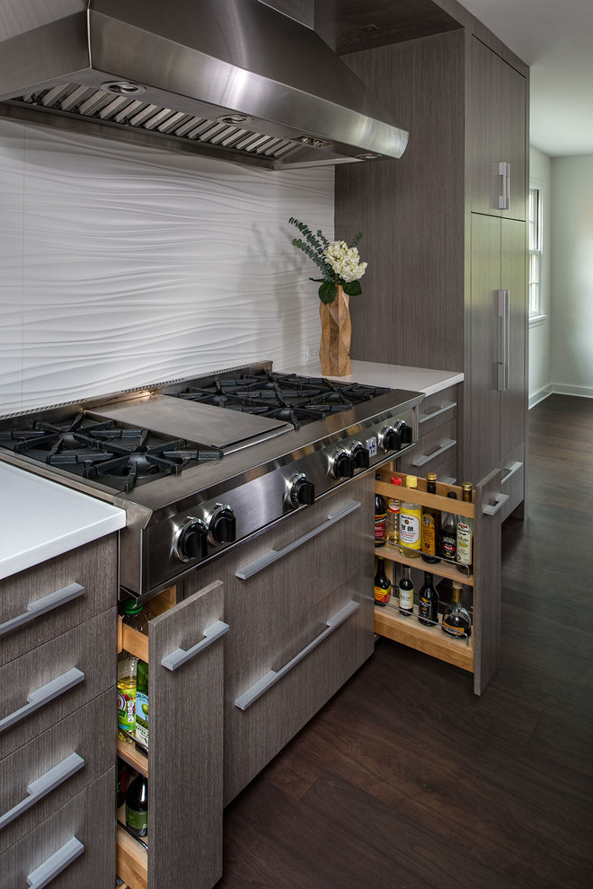 Foto på ett funkis kök, med en undermonterad diskho, grå skåp, bänkskiva i kvarts, vitt stänkskydd, stänkskydd i keramik, rostfria vitvaror och mörkt trägolv