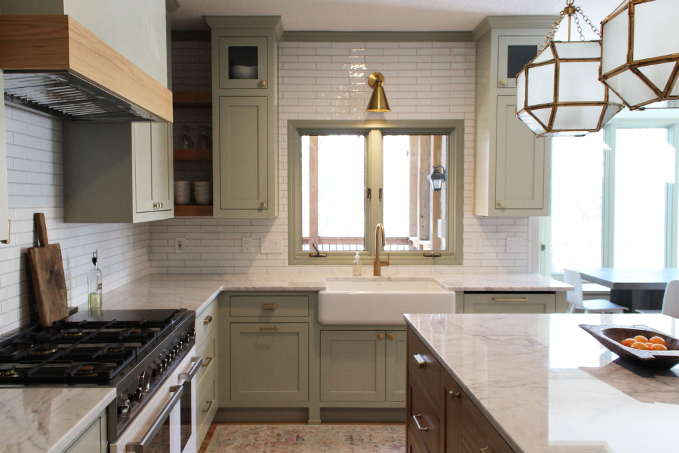Eat-in kitchen - mid-sized transitional u-shaped light wood floor eat-in kitchen idea in Kansas City with a farmhouse sink, shaker cabinets, green cabinets, quartz countertops, white backsplash, subway tile backsplash, white appliances, an island and white countertops