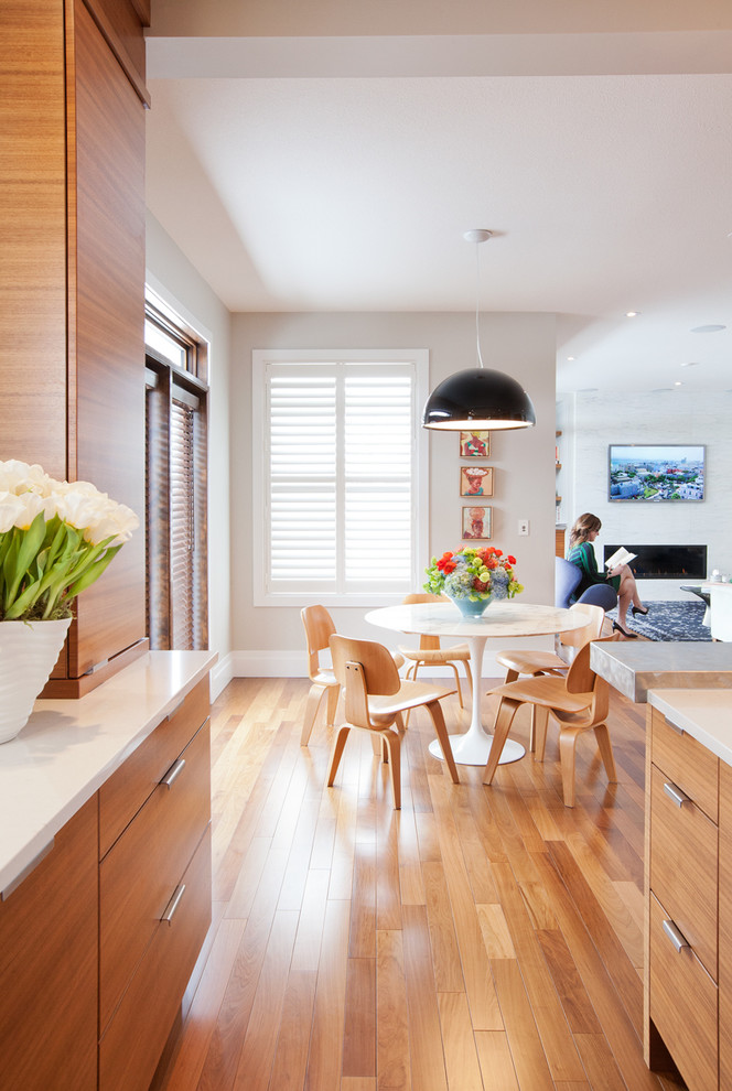 На фото: кухня в современном стиле с обеденным столом, плоскими фасадами и фасадами цвета дерева среднего тона