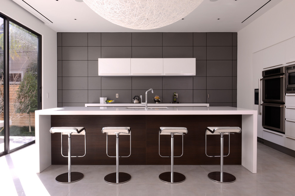 Esempio di una grande cucina moderna con ante lisce, ante bianche, top in granito, paraspruzzi grigio, elettrodomestici in acciaio inossidabile e pavimento con piastrelle in ceramica