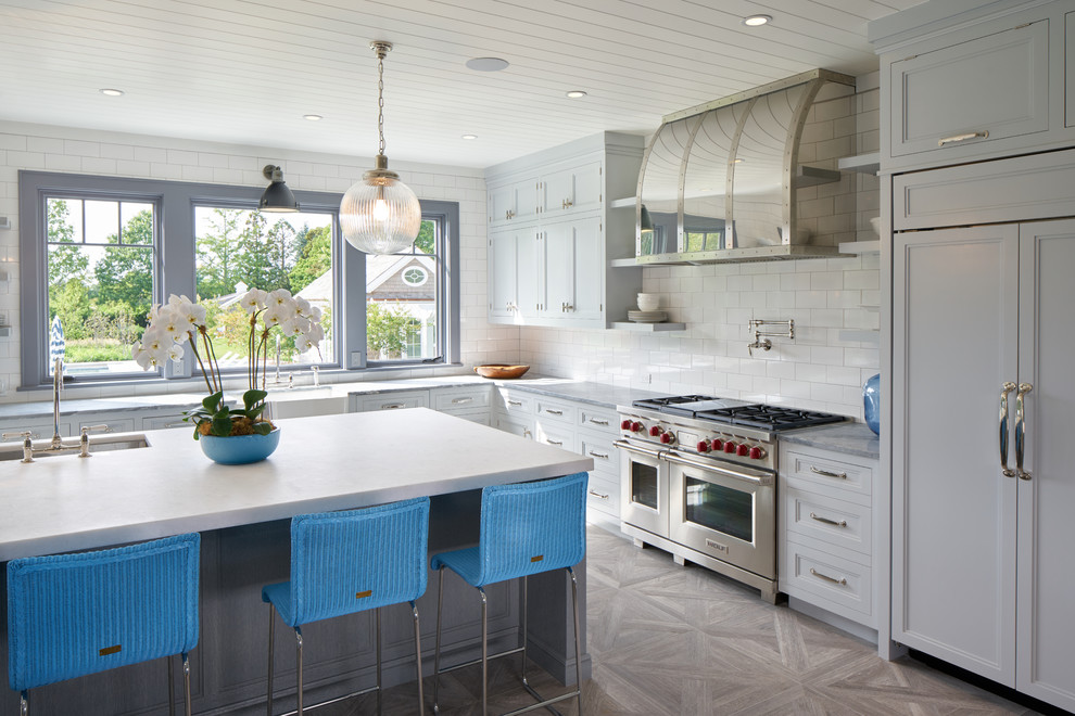 Eat-in kitchen - large transitional l-shaped medium tone wood floor and gray floor eat-in kitchen idea in New York with an undermount sink, recessed-panel cabinets, white cabinets, quartzite countertops, white backsplash, subway tile backsplash, paneled appliances and an island