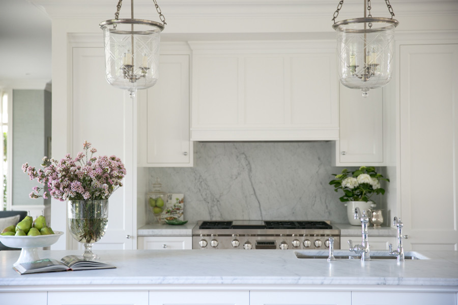 Imagen de cocina clásica con armarios estilo shaker, puertas de armario blancas y encimera de mármol
