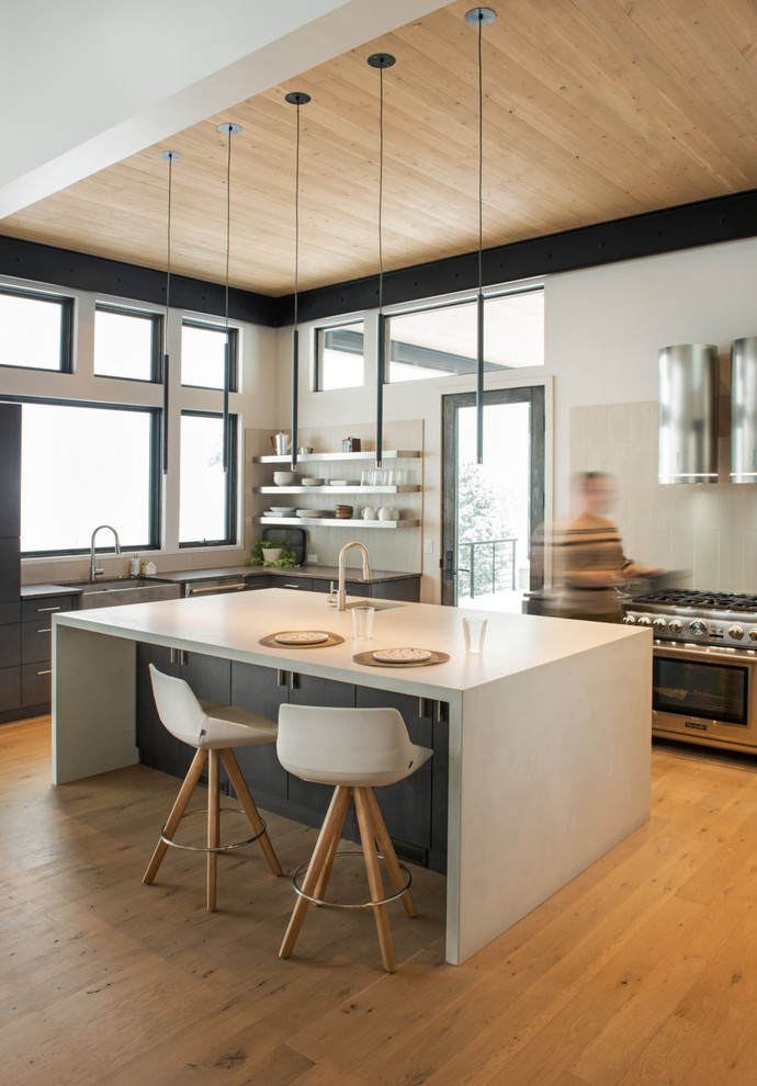 Rustikale Küche in L-Form mit Landhausspüle, Küchengeräten aus Edelstahl, hellem Holzboden, Kücheninsel und weißer Arbeitsplatte in Sonstige