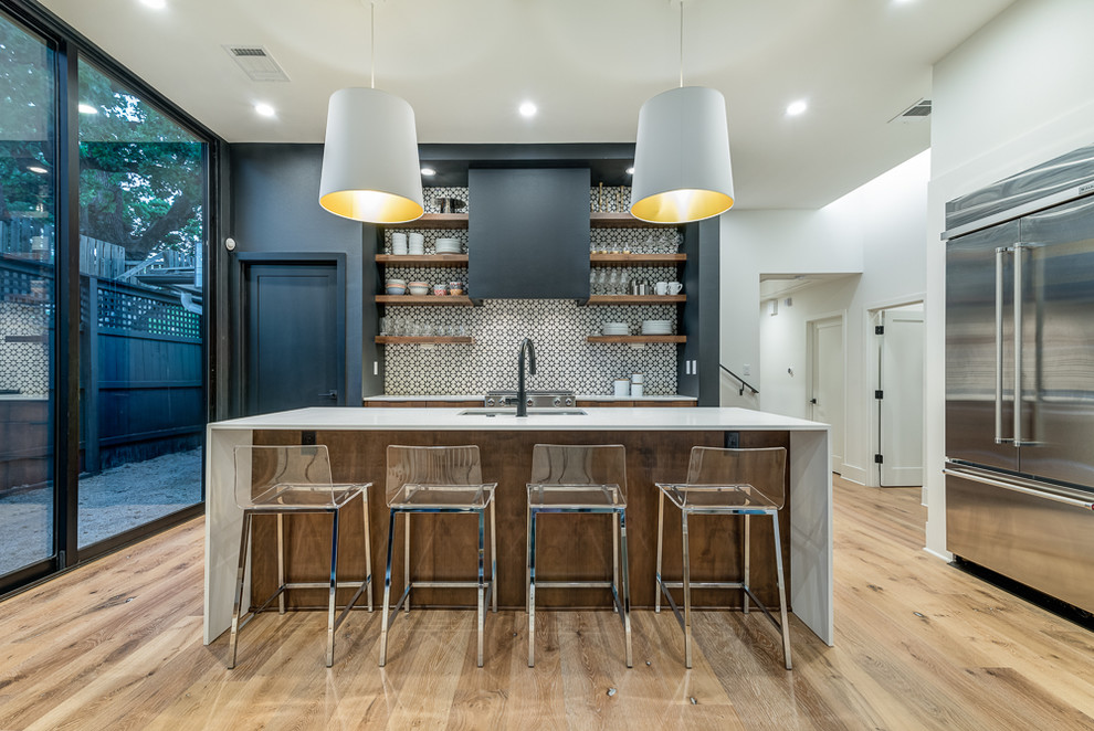 Moderne Küche mit Unterbauwaschbecken, bunter Rückwand, hellem Holzboden, Kücheninsel und weißer Arbeitsplatte in Austin