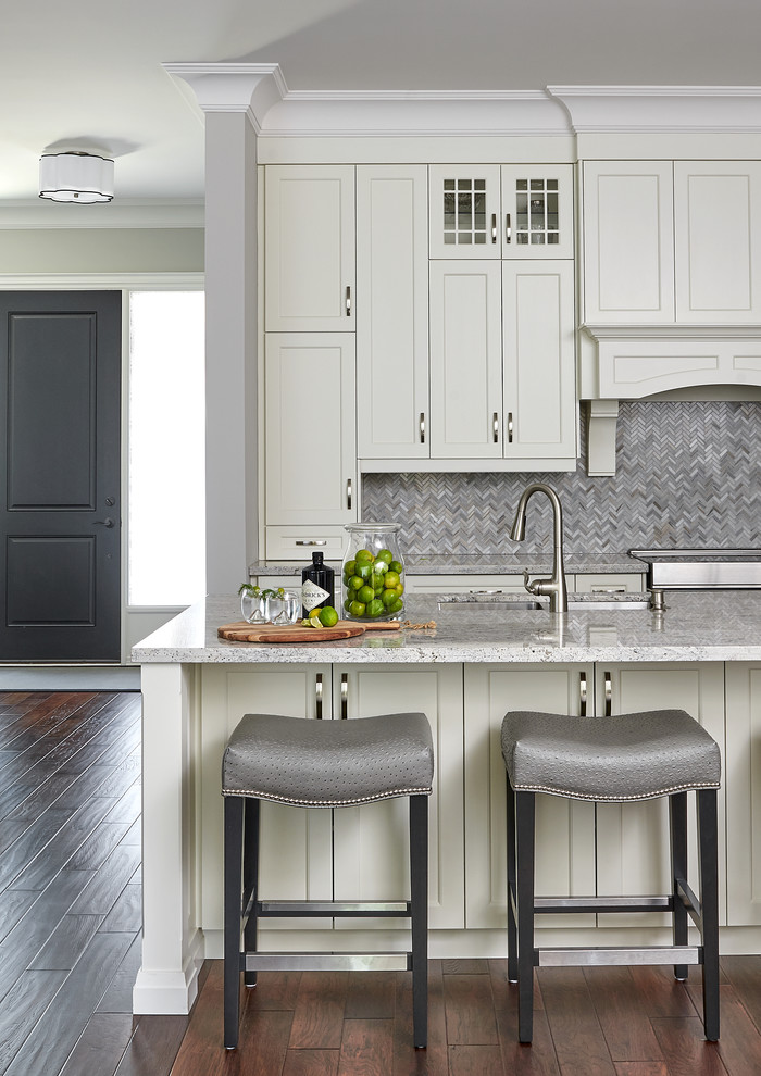 Example of a mid-sized transitional medium tone wood floor kitchen design in Toronto with an undermount sink, shaker cabinets, white cabinets, quartzite countertops, gray backsplash, stainless steel appliances, an island and gray countertops