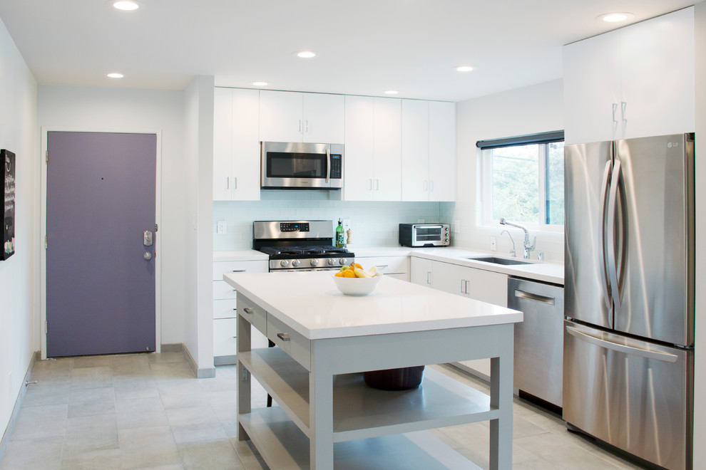 Example of a mid-sized minimalist l-shaped porcelain tile eat-in kitchen design in Los Angeles with an undermount sink, white cabinets, quartz countertops, glass tile backsplash, stainless steel appliances, an island, flat-panel cabinets and white backsplash