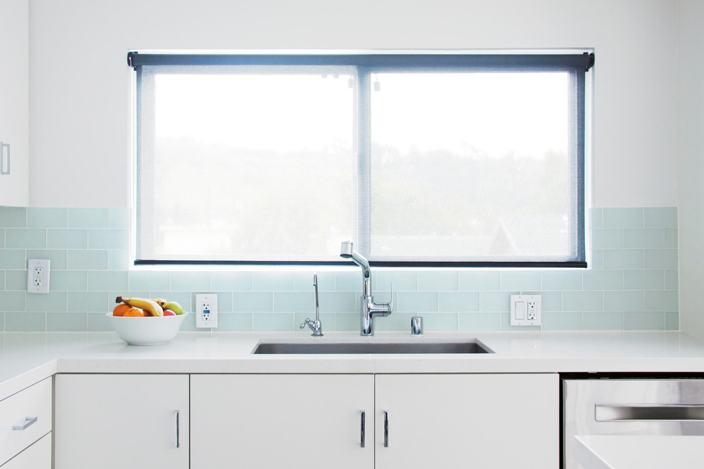 Immagine di una cucina minimalista di medie dimensioni con lavello sottopiano, ante bianche, top in quarzo composito, paraspruzzi con piastrelle di vetro, elettrodomestici in acciaio inossidabile, pavimento in gres porcellanato, ante lisce e paraspruzzi bianco