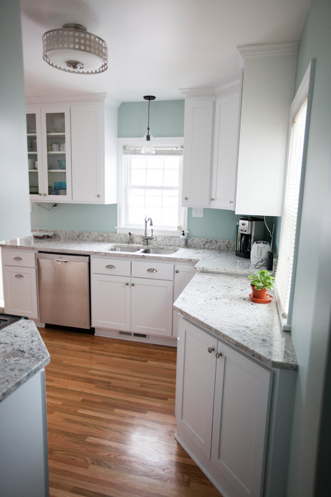 Exempel på ett mellanstort lantligt kök, med en dubbel diskho, skåp i shakerstil, vita skåp, marmorbänkskiva, vitt stänkskydd, stänkskydd i sten, rostfria vitvaror och mellanmörkt trägolv