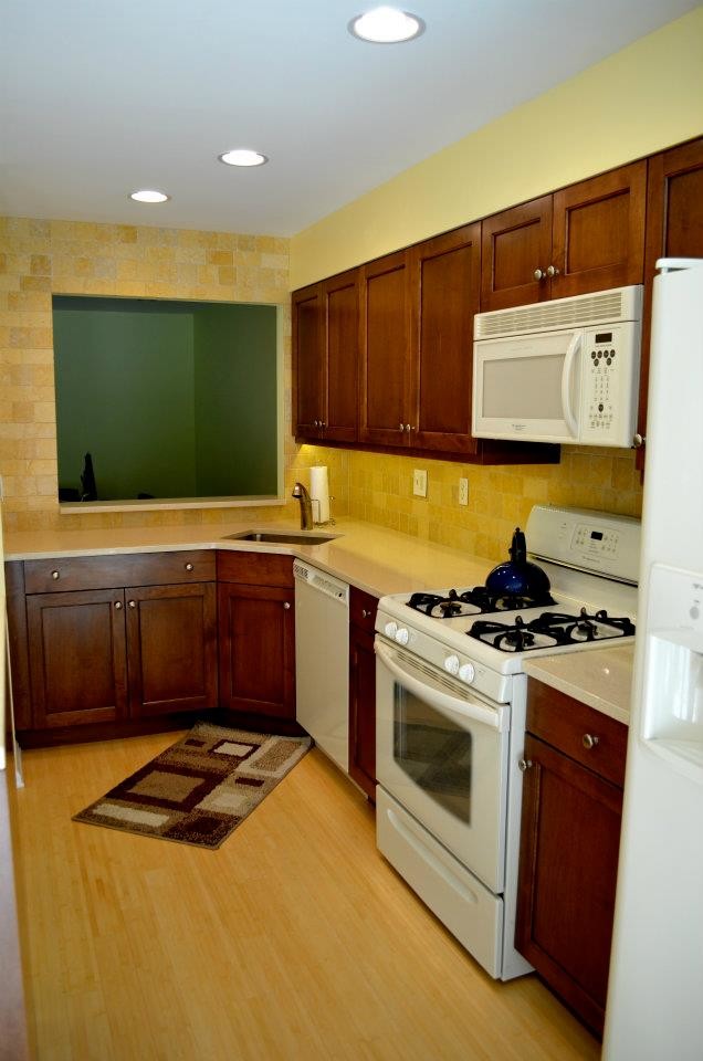 Eat-in kitchen - transitional l-shaped eat-in kitchen idea in New York with an undermount sink, recessed-panel cabinets, medium tone wood cabinets, quartz countertops, yellow backsplash, porcelain backsplash and white appliances