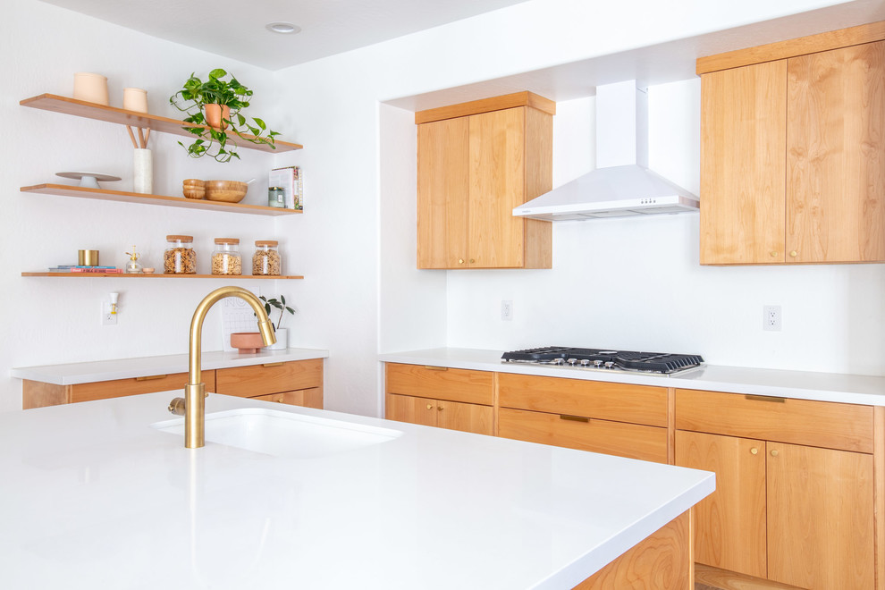 Immagine di una cucina minimalista di medie dimensioni con lavello sottopiano, ante lisce, ante in legno chiaro, top in quarzo composito, paraspruzzi bianco, elettrodomestici in acciaio inossidabile, parquet chiaro, pavimento marrone e top bianco