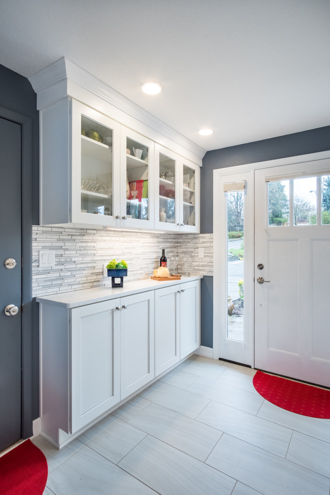Large transitional l-shaped ceramic tile and white floor open concept kitchen photo in Portland with an undermount sink, shaker cabinets, white cabinets, quartz countertops, multicolored backsplash, glass tile backsplash, stainless steel appliances, an island and white countertops