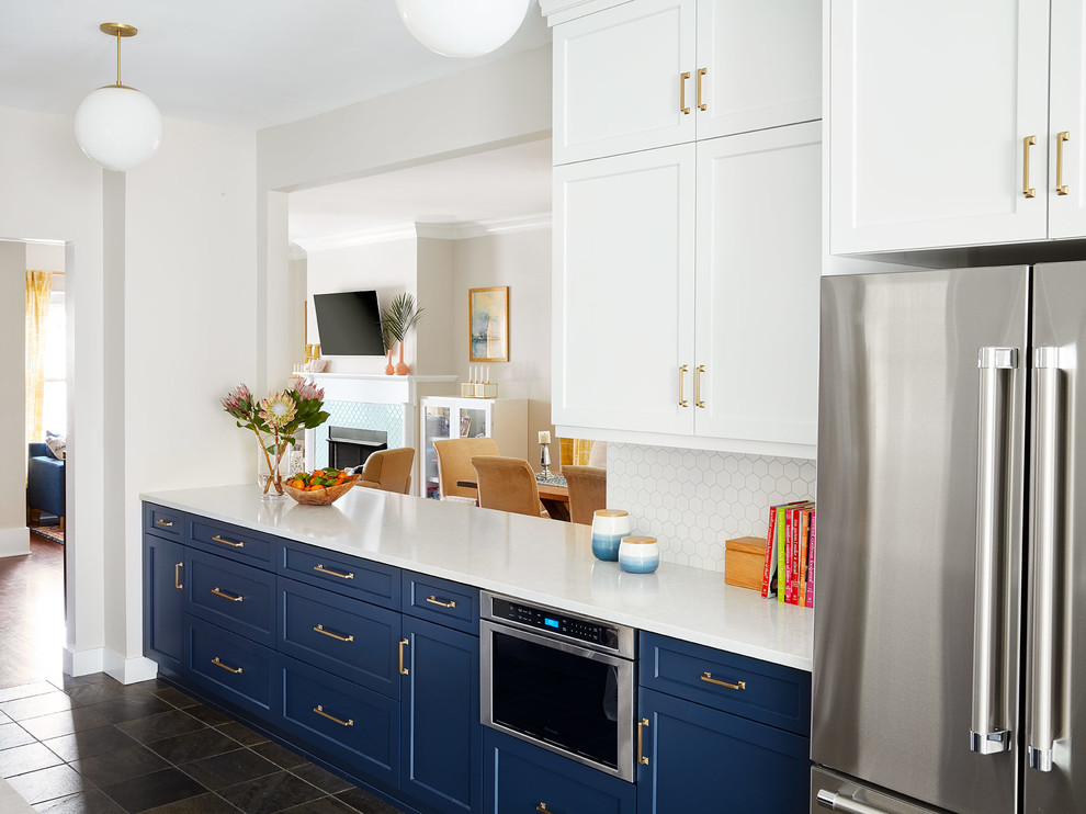Bild på ett funkis vit vitt kök, med en enkel diskho, skåp i shakerstil, blå skåp, bänkskiva i kvarts, vitt stänkskydd, stänkskydd i keramik, rostfria vitvaror, skiffergolv och grönt golv