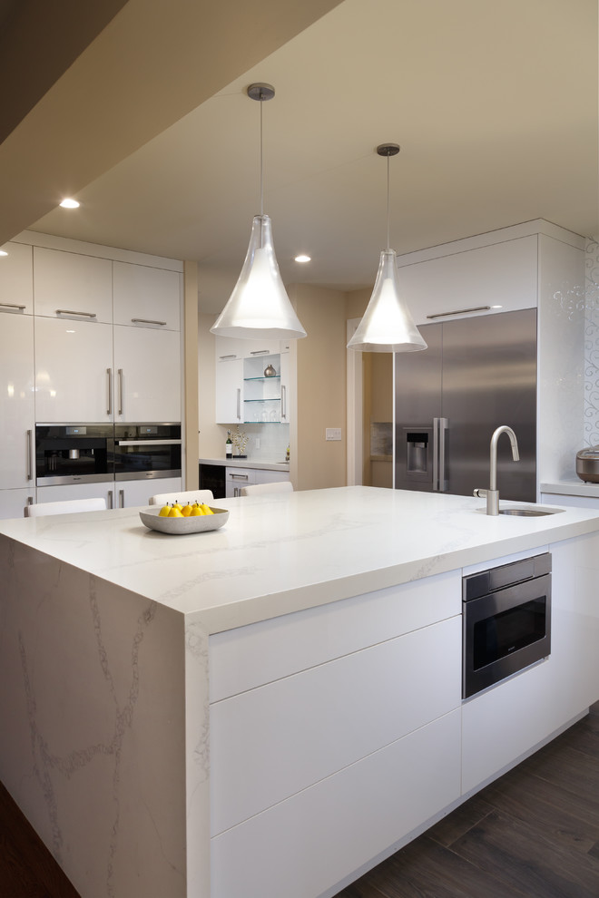Inspiration for a large modern u-shaped dark wood floor and brown floor kitchen remodel in Philadelphia with a single-bowl sink, flat-panel cabinets, white cabinets, quartz countertops, white backsplash, cement tile backsplash, stainless steel appliances, an island and white countertops