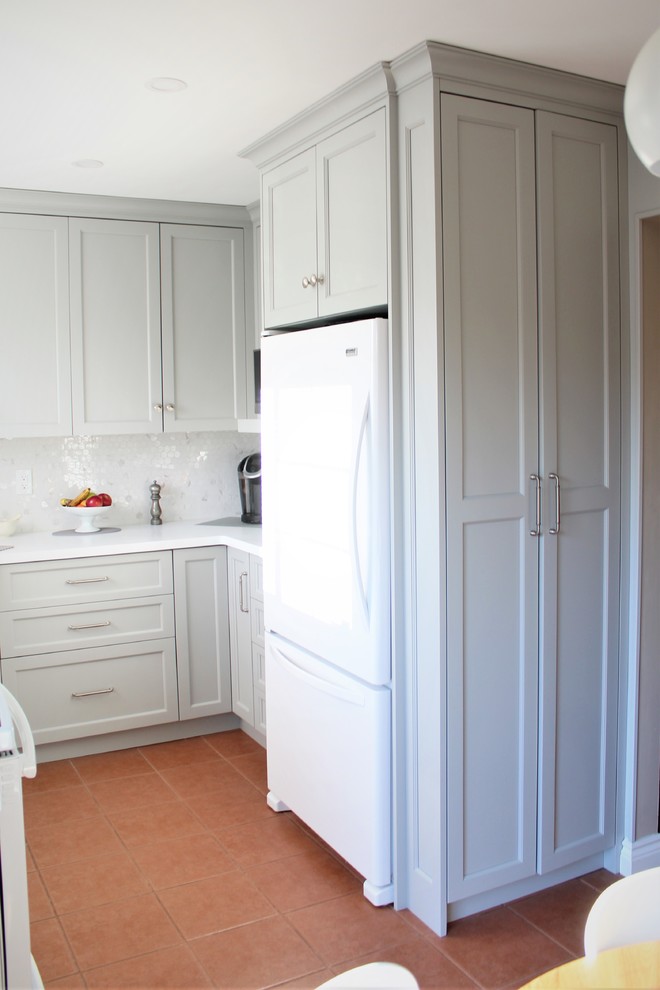 Inredning av ett klassiskt litet vit vitt kök, med en undermonterad diskho, skåp i shakerstil, grå skåp, bänkskiva i kvarts, vitt stänkskydd, vita vitvaror, terrazzogolv, rött golv och stänkskydd i mosaik