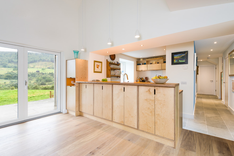 Inspiration for a medium sized scandi l-shaped open plan kitchen in Other with light wood cabinets, wood worktops, white splashback, glass sheet splashback, integrated appliances and a breakfast bar.