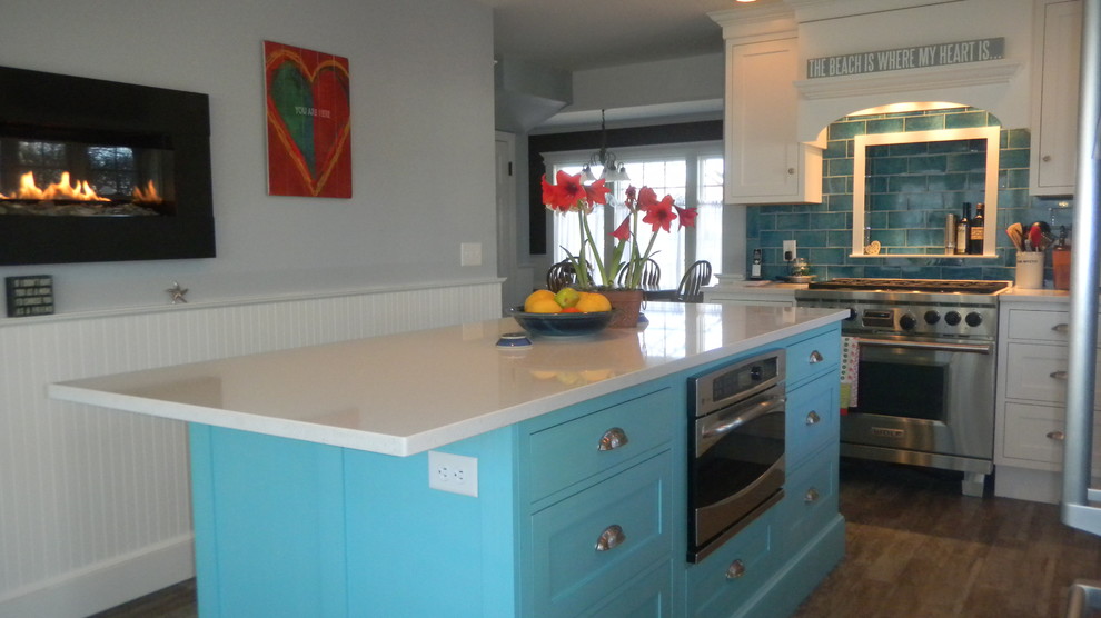 Foto på ett mellanstort vintage kök, med en dubbel diskho, luckor med infälld panel, vita skåp, bänkskiva i kvarts, blått stänkskydd, stänkskydd i tunnelbanekakel, rostfria vitvaror, mörkt trägolv och en köksö