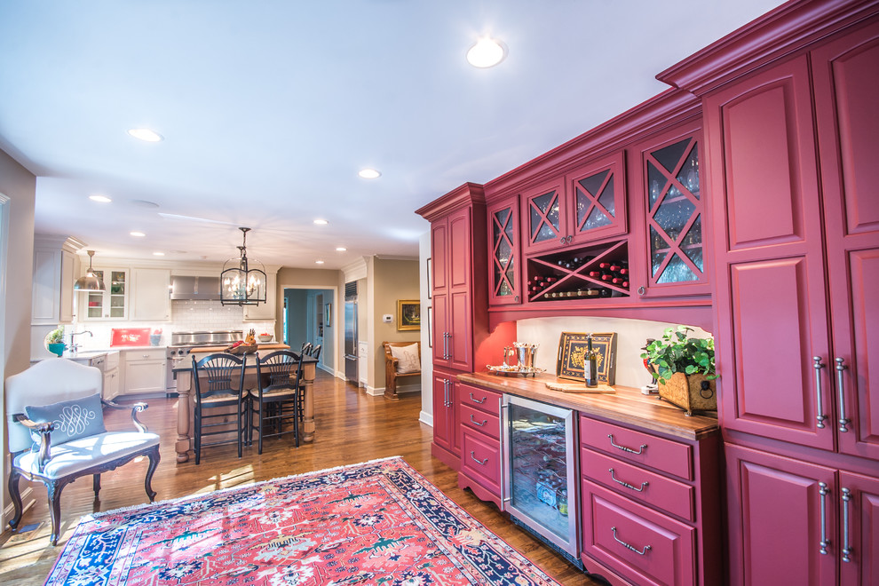 Foto di una cucina classica con ante con bugna sagomata, ante rosse, pavimento in legno massello medio e top in legno