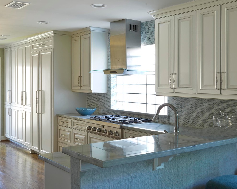Klassisk inredning av ett kök, med granitbänkskiva, rostfria vitvaror och mellanmörkt trägolv