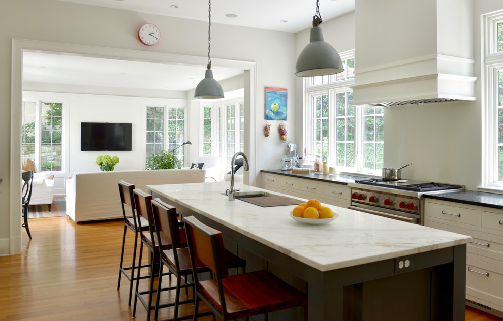 Large farmhouse l-shaped medium tone wood floor and orange floor kitchen photo in DC Metro with an undermount sink, shaker cabinets, black cabinets, marble countertops, stainless steel appliances and an island