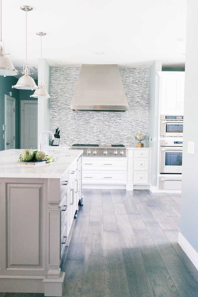 Eat-in kitchen - large transitional u-shaped dark wood floor and gray floor eat-in kitchen idea in Other with a triple-bowl sink, raised-panel cabinets, white cabinets, quartz countertops, gray backsplash, marble backsplash, stainless steel appliances, two islands and white countertops