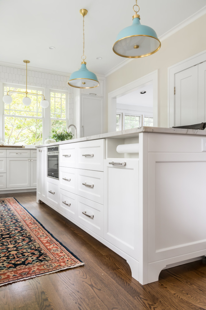 Eat-in kitchen - large coastal galley dark wood floor and brown floor eat-in kitchen idea in Atlanta with an undermount sink, shaker cabinets, white cabinets, quartzite countertops, white backsplash, marble backsplash, paneled appliances, an island and white countertops