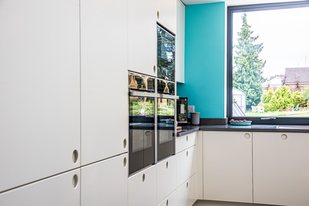 Immagine di un'ampia cucina minimalista con ante lisce, ante bianche, top in quarzite, pavimento grigio, top bianco e soffitto a volta