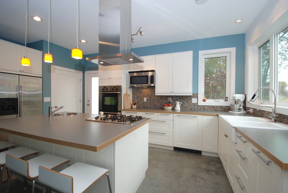 Modern inredning av ett mellanstort kök, med en rustik diskho, skåp i shakerstil, vita skåp, rostfria vitvaror, laminatbänkskiva, flerfärgad stänkskydd, stänkskydd i glaskakel och betonggolv