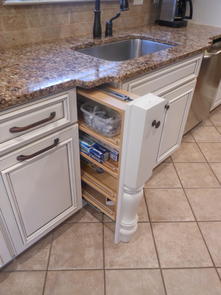 Example of a small classic ceramic tile eat-in kitchen design in Birmingham with an undermount sink, raised-panel cabinets, white cabinets, granite countertops, beige backsplash, stone tile backsplash, stainless steel appliances and no island