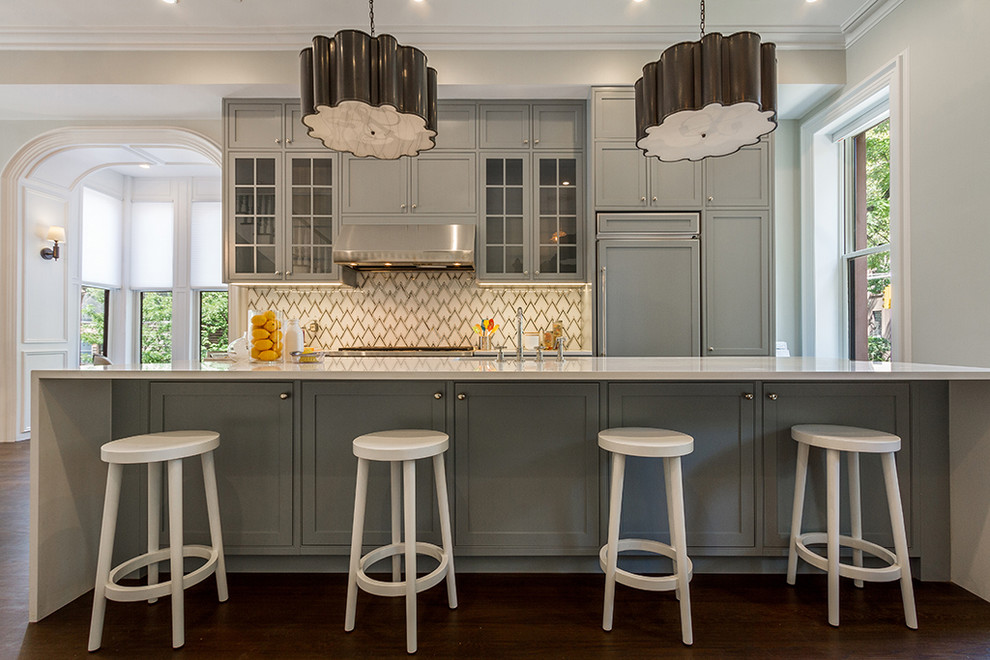 Idéer för ett mellanstort klassiskt linjärt kök med öppen planlösning, med luckor med profilerade fronter, grå skåp, bänkskiva i kvarts, flerfärgad stänkskydd, stänkskydd i marmor, integrerade vitvaror, mellanmörkt trägolv, en köksö, brunt golv och en undermonterad diskho