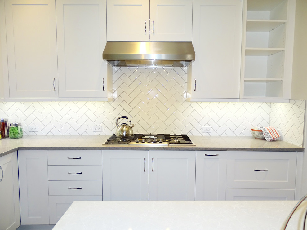 Large transitional galley ceramic tile eat-in kitchen photo in Austin with a drop-in sink, beaded inset cabinets, white cabinets, quartzite countertops, white backsplash, ceramic backsplash, stainless steel appliances and an island