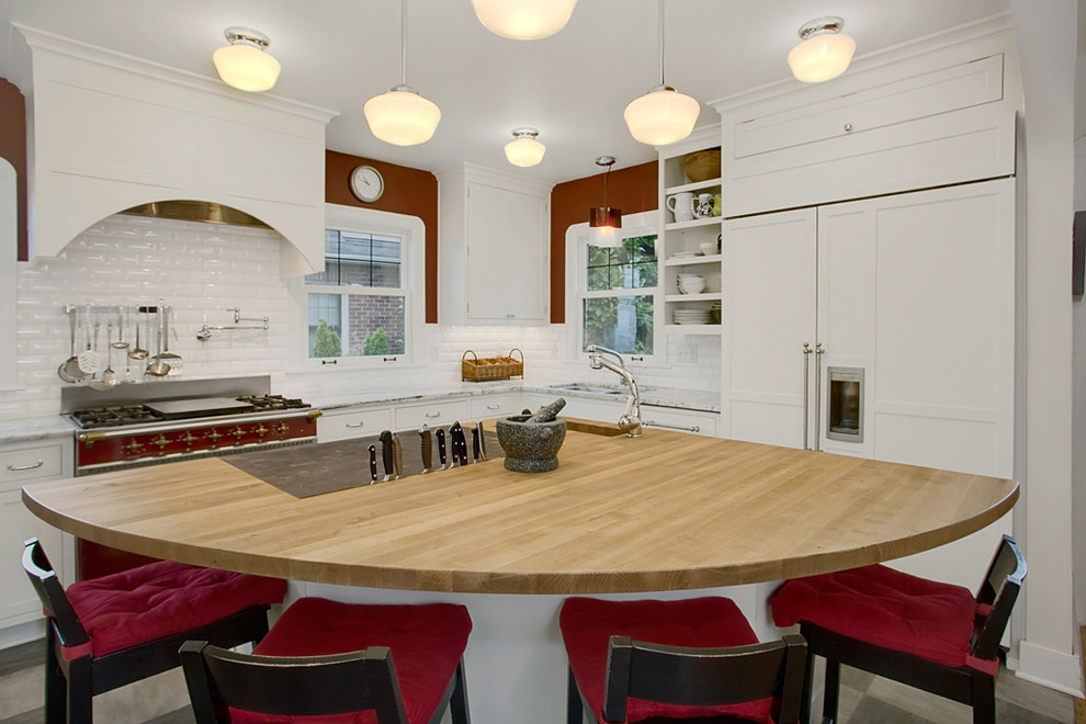 Пример оригинального дизайна: кухня в классическом стиле с обеденным столом, врезной мойкой, плоскими фасадами, белыми фасадами, деревянной столешницей, белым фартуком, фартуком из удлиненной плитки и цветной техникой