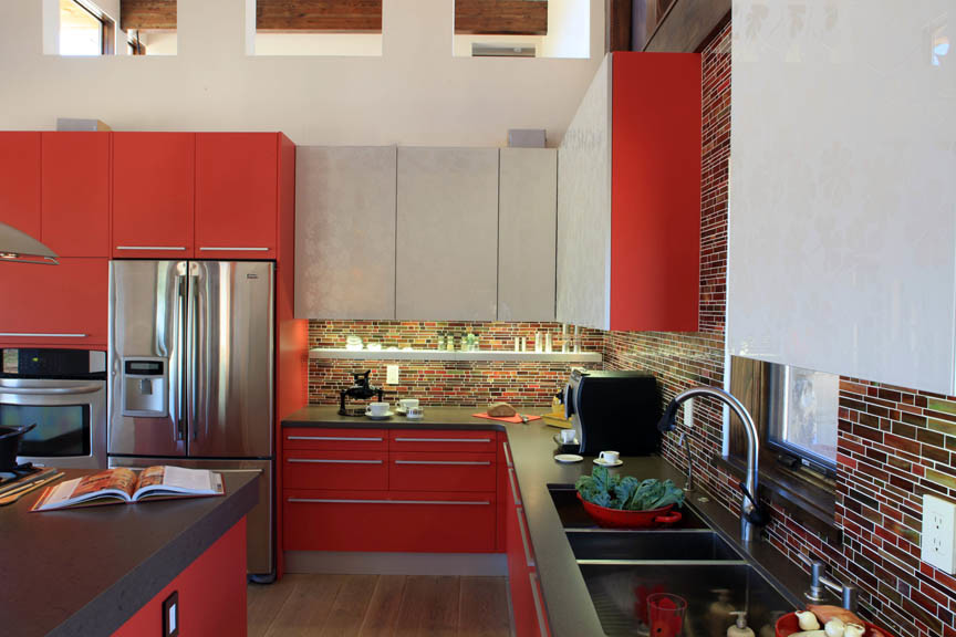 Example of a large trendy l-shaped light wood floor open concept kitchen design in Denver with an undermount sink, flat-panel cabinets, red cabinets, quartz countertops, multicolored backsplash, glass tile backsplash, stainless steel appliances and an island