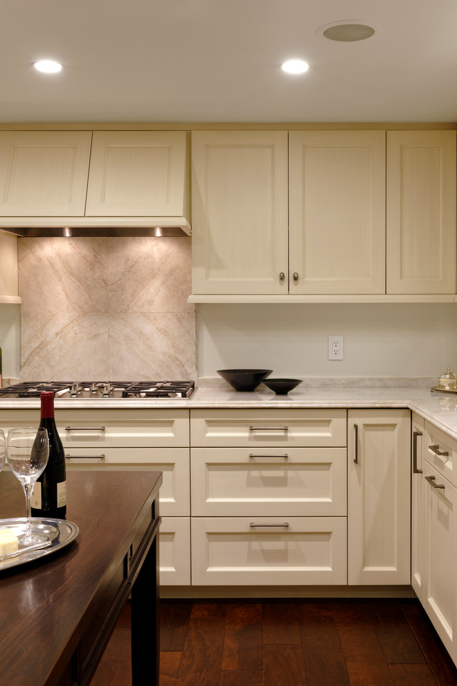 Example of a classic medium tone wood floor kitchen design in DC Metro with an undermount sink, quartzite countertops, paneled appliances and an island