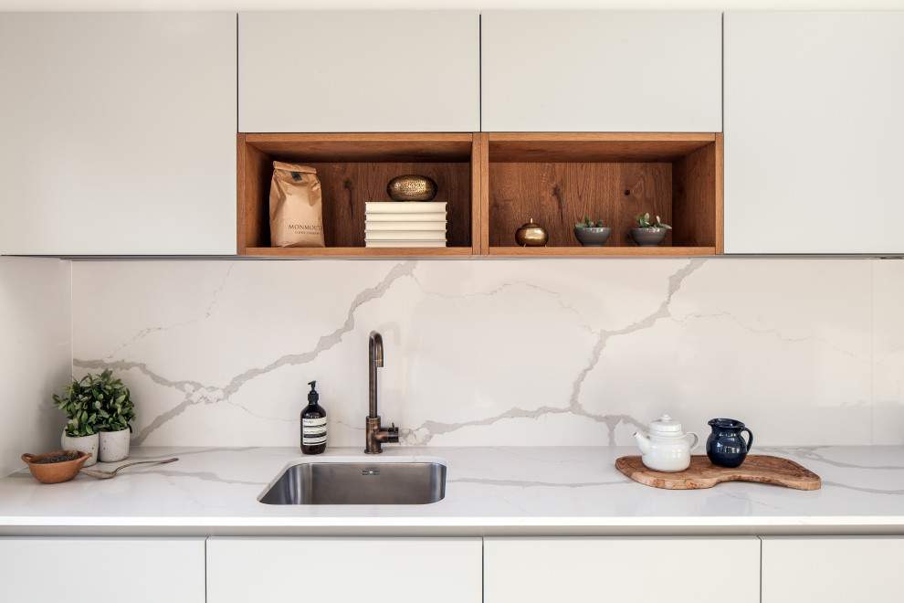 Mid-sized minimalist l-shaped kitchen photo in London with an undermount sink, flat-panel cabinets, quartzite countertops, white backsplash, quartz backsplash, paneled appliances, no island and white countertops