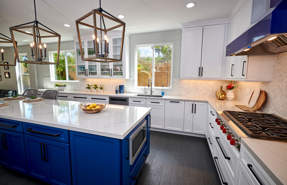 Large beach style u-shaped porcelain tile and black floor open concept kitchen photo in San Diego with an undermount sink, shaker cabinets, white cabinets, quartz countertops, white backsplash, marble backsplash, stainless steel appliances, an island and gray countertops