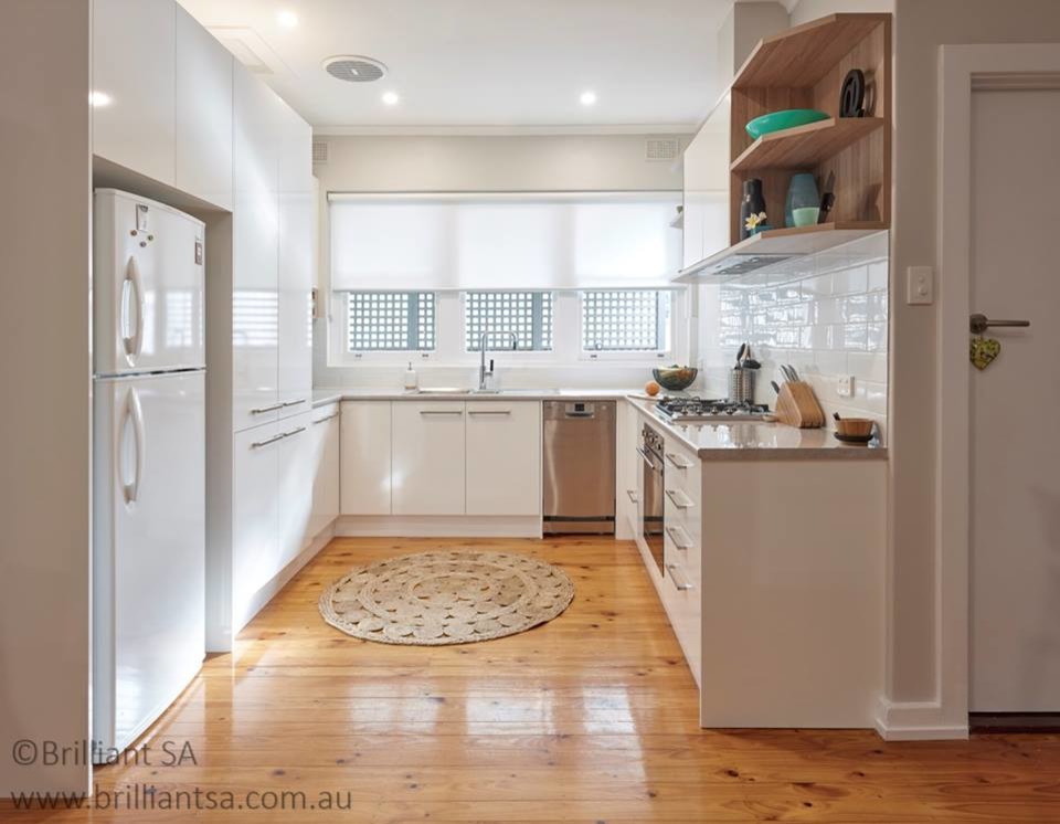 Immagine di una piccola cucina design con paraspruzzi bianco, paraspruzzi con piastrelle in ceramica e pavimento in legno massello medio