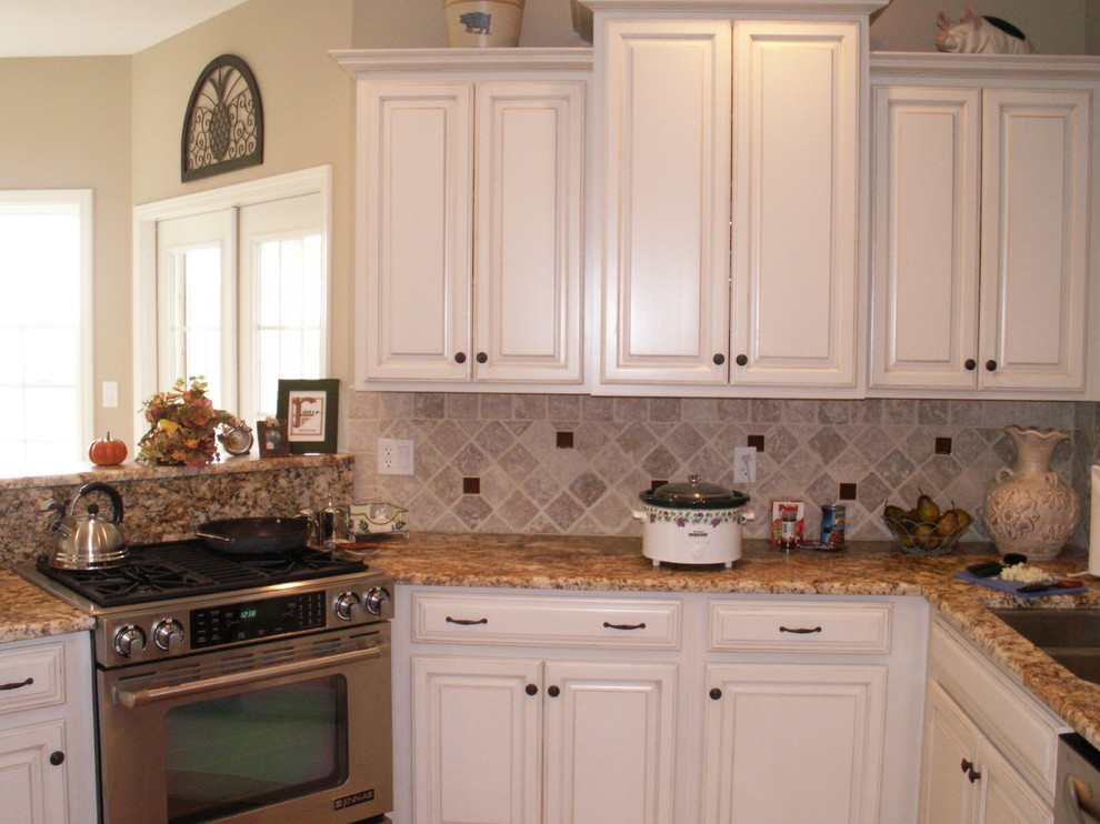 Exempel på ett litet klassiskt kök, med en dubbel diskho, luckor med upphöjd panel, vita skåp, granitbänkskiva, beige stänkskydd, stänkskydd i stenkakel, rostfria vitvaror och ljust trägolv