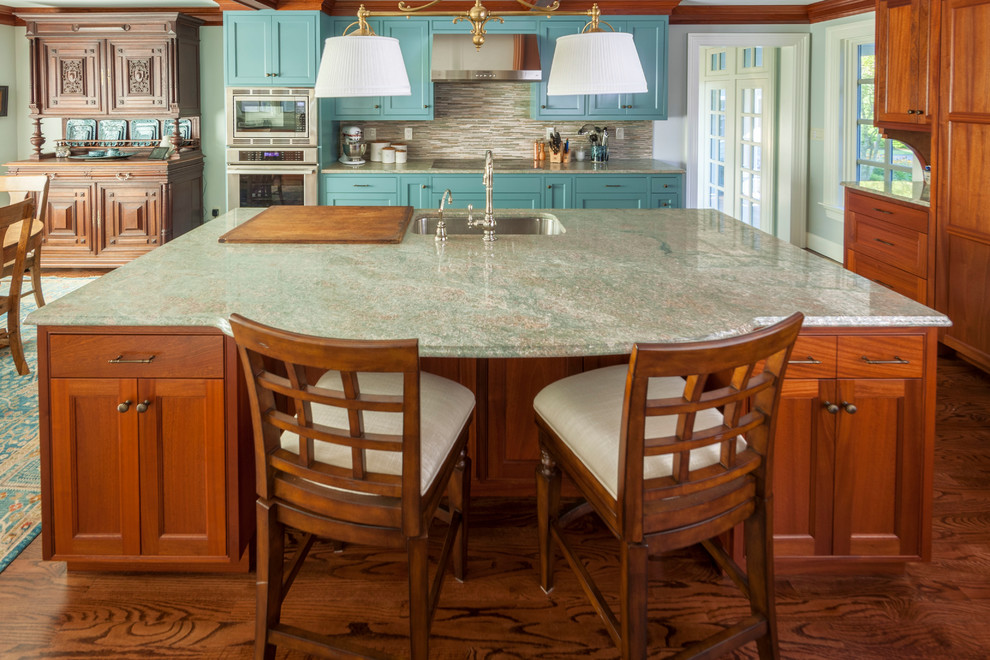 Inredning av ett klassiskt stort turkos linjärt turkost kök och matrum, med en enkel diskho, skåp i shakerstil, blå skåp, granitbänkskiva, brunt stänkskydd, stänkskydd i glaskakel, rostfria vitvaror och en köksö