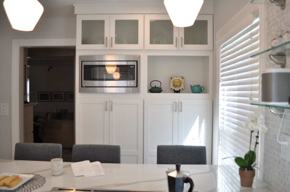 Exempel på ett avskilt, mellanstort modernt vit vitt u-kök, med en undermonterad diskho, skåp i shakerstil, vita skåp, bänkskiva i kvarts, flerfärgad stänkskydd, stänkskydd i mosaik, rostfria vitvaror, bambugolv och en köksö