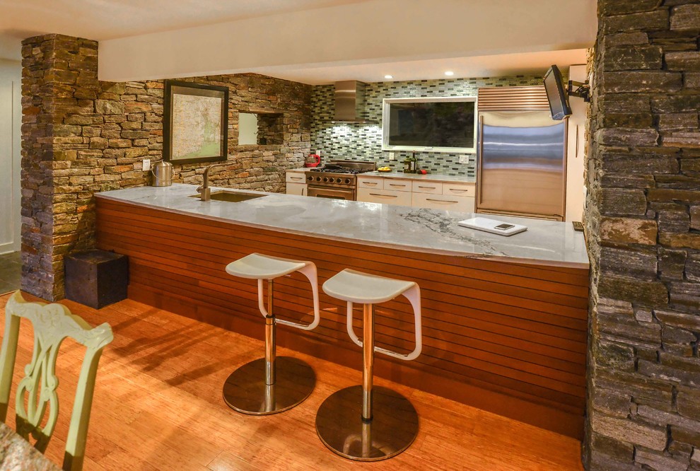 Foto på ett mellanstort funkis kök, med en undermonterad diskho, släta luckor, vita skåp, bänkskiva i kvarts, grått stänkskydd, stänkskydd i stickkakel, rostfria vitvaror, mellanmörkt trägolv och brunt golv