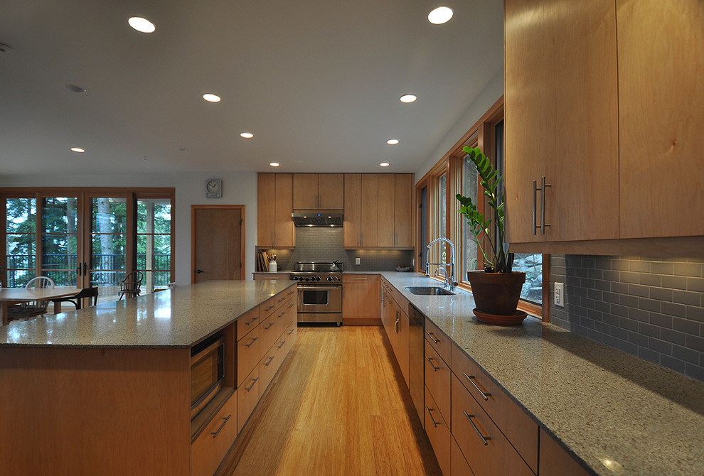 Inspiration for a large contemporary l-shaped bamboo floor open concept kitchen remodel in Vancouver with an undermount sink, flat-panel cabinets, light wood cabinets, quartz countertops, gray backsplash, subway tile backsplash, stainless steel appliances and an island