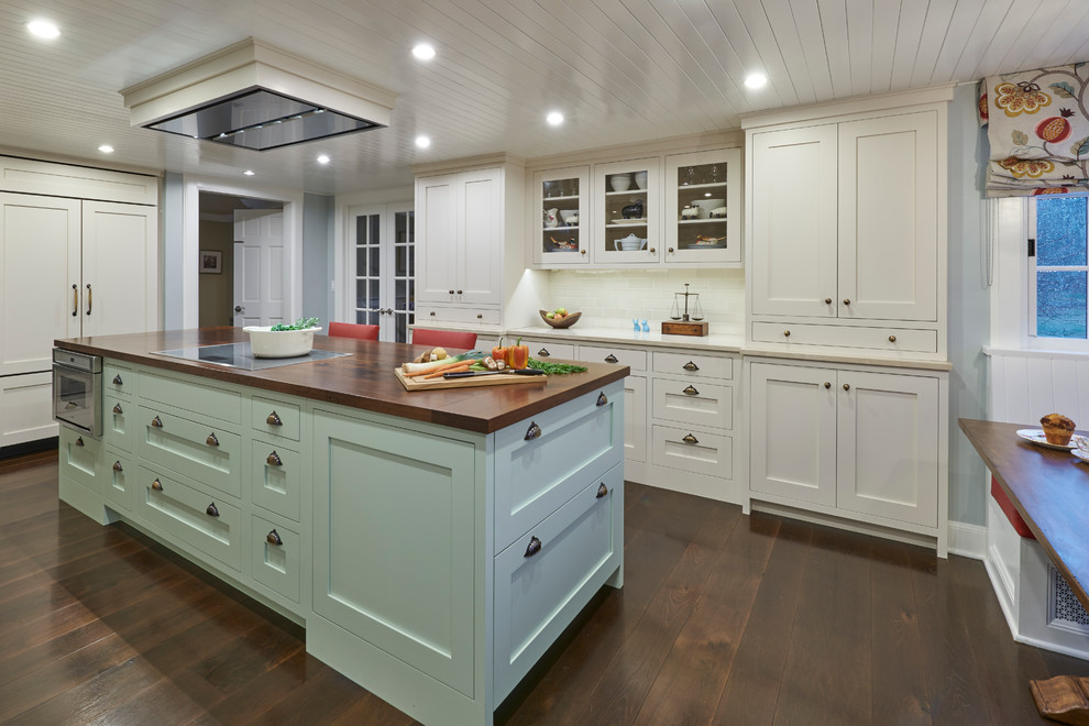 Large cottage dark wood floor eat-in kitchen photo in New York with a farmhouse sink, shaker cabinets, white cabinets, beige backsplash, ceramic backsplash, stainless steel appliances and an island