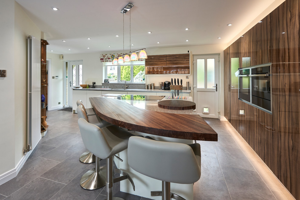 This is an example of a medium sized contemporary l-shaped kitchen in Other with a double-bowl sink, flat-panel cabinets, medium wood cabinets, wood worktops, integrated appliances, an island and grey floors.