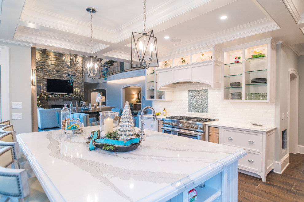 Large transitional single-wall vinyl floor and brown floor open concept kitchen photo in Providence with white cabinets, quartz countertops, white backsplash, stainless steel appliances, an island, an undermount sink, recessed-panel cabinets, subway tile backsplash and white countertops